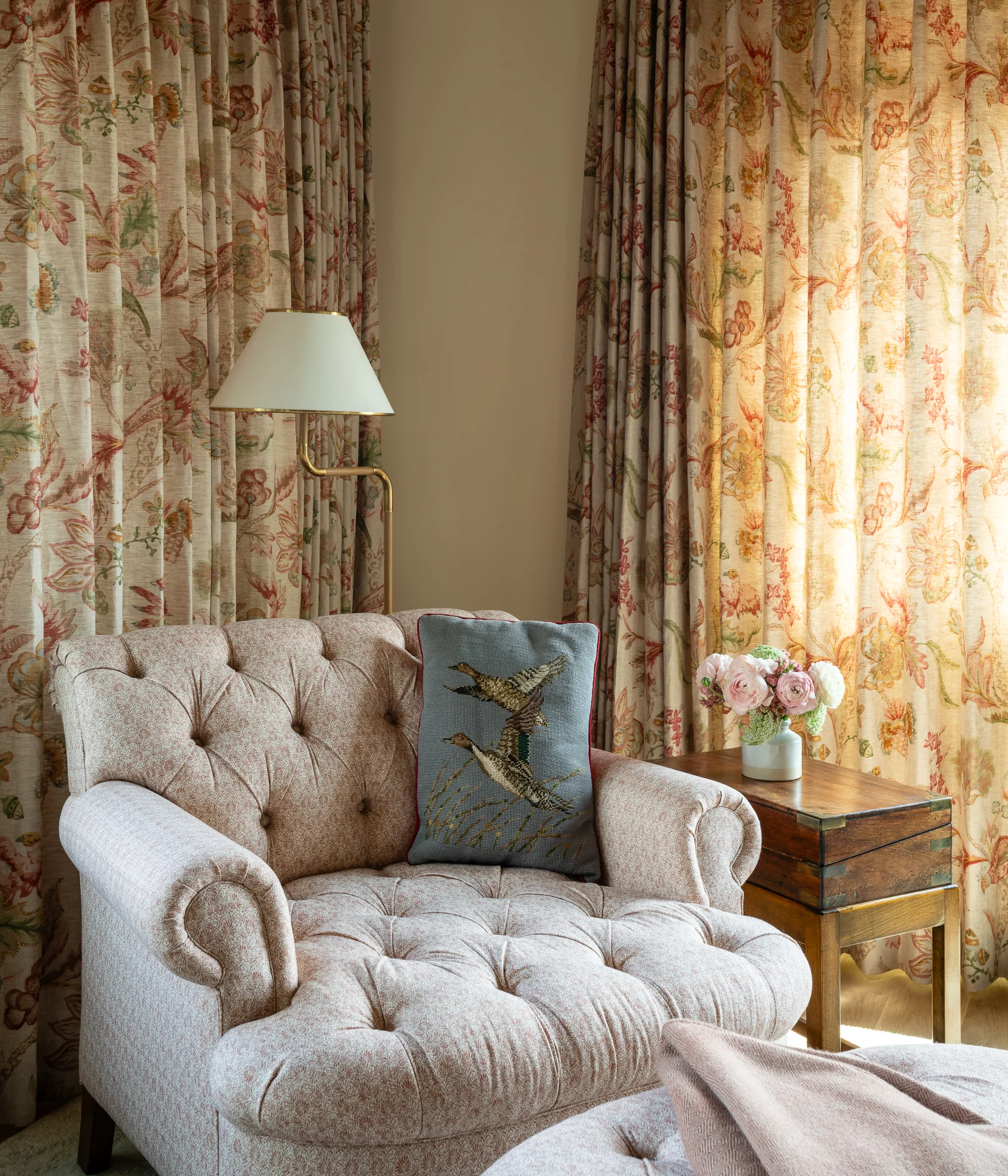 Reading nook armchair styled with floral curtains and a vintage side table — interior design photography Driggs Idaho, WTG Architects